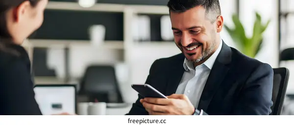 Smiling Businessman Looking at His Phone