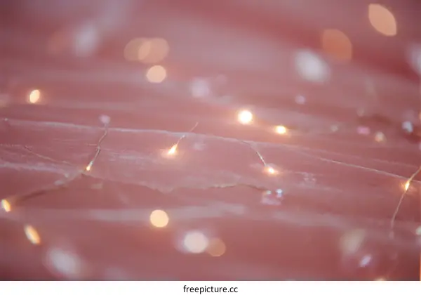 Soft pink background with warm glowing fairy lights