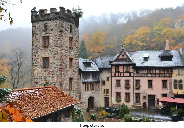 Stone Tower and Timber Frame Houses in a Snowy Autumn Village