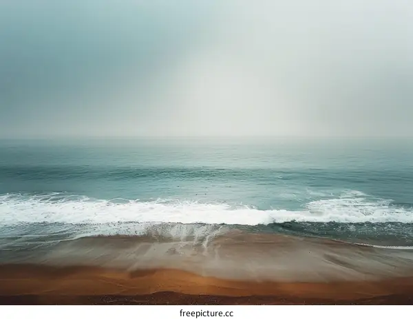 The peaceful beach with sea waves and a sandy beach