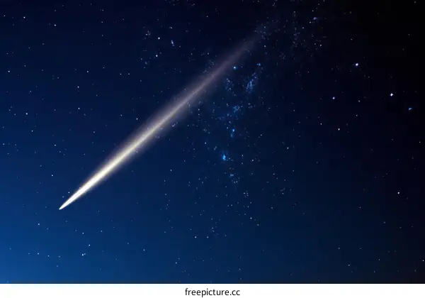 Spectacular view of a comet with bright glowing tail in deep dark blue starry night sky