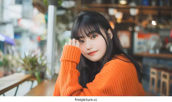 Portrait of Young Asian Woman Wearing Orange Sweater
