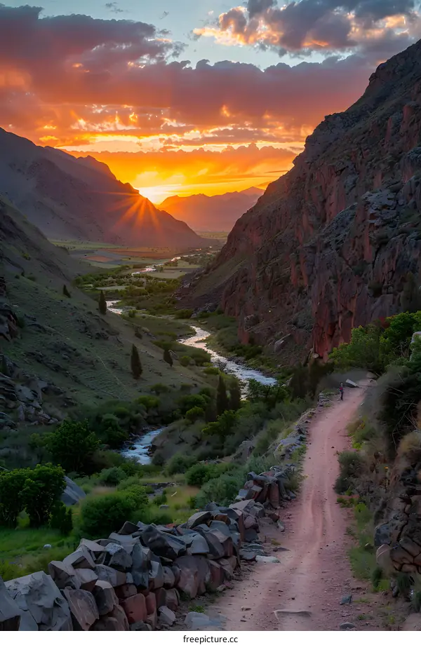 hiker on mountain path at sunset