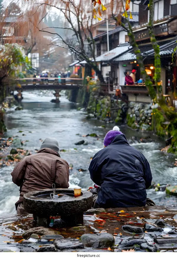 Two People Sitting by a River in Japan