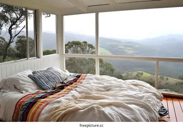 White Bed with Mountain View Through Large Window