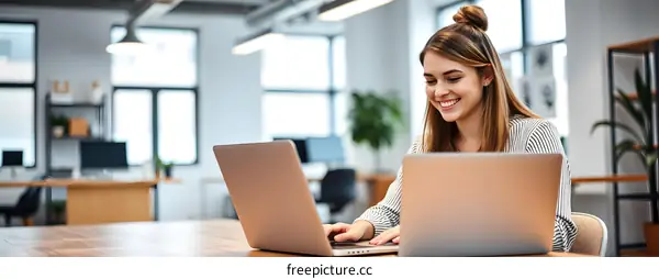 Smiling Woman Working on Laptop in Modern Office