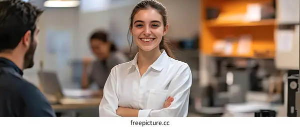 Smiling Woman with Arms Crossed in Office Setting
