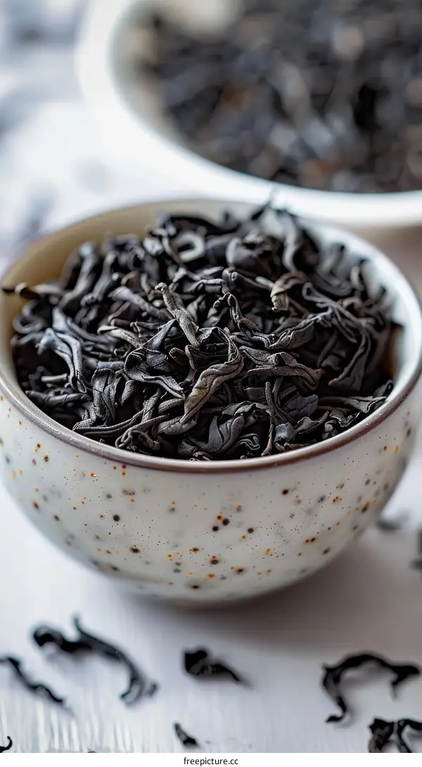 Black tea leaves in a white ceramic bowl