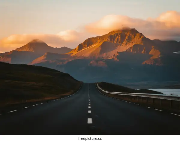 Scenic road with mountains under a colorful sky during sunset