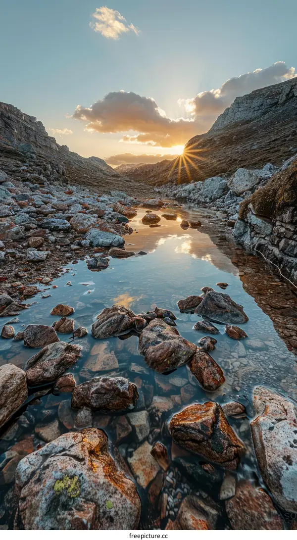 Sunset over rocky river flowing through mountain valley