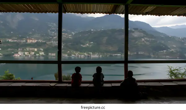 Three Boys Looking at Mountain View Through Window