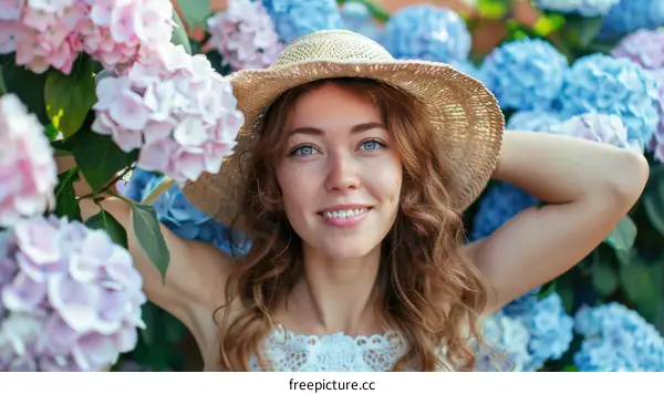 Close-up portrait of a beautiful young woman standing in a garden of hydrangeas