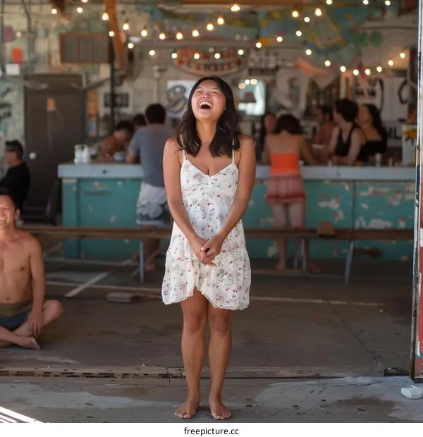 Laughing woman in a white dress in front of a group of people