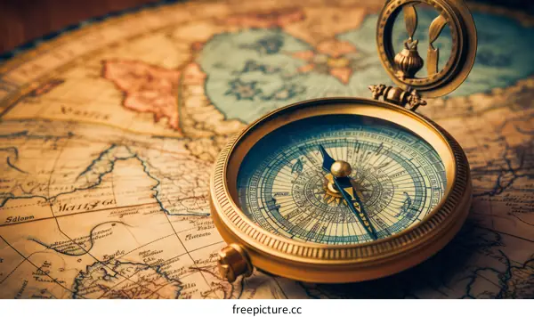 A golden compass sits on top of an old world map.