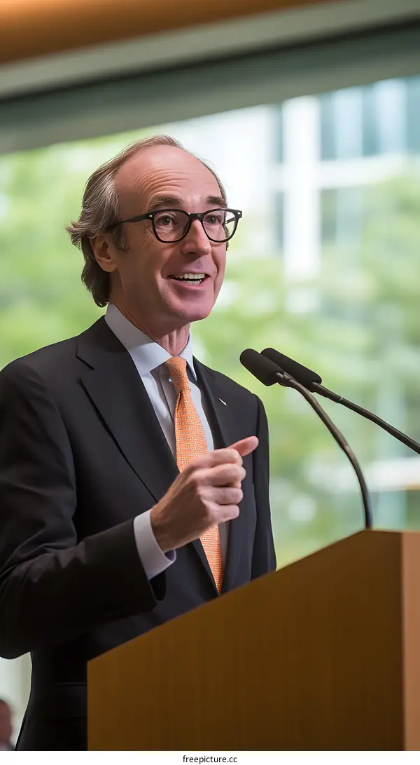Man in Suit Speaking at Podium