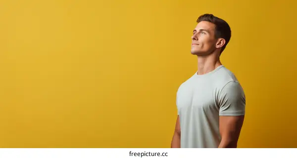 Handsome young man wearing a gray shirt looking off to the side