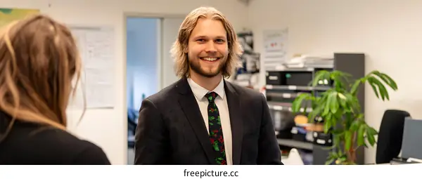 Smiling Man in Suit Looking at Camera in Office