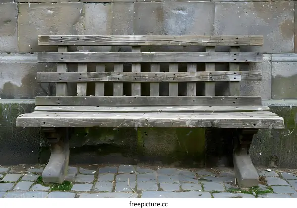 Old Wooden Bench Against a Stone Wall