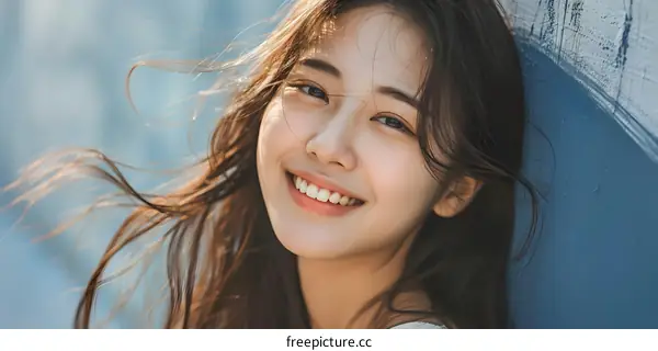 Smiling Woman with Long Hair and Blue Background