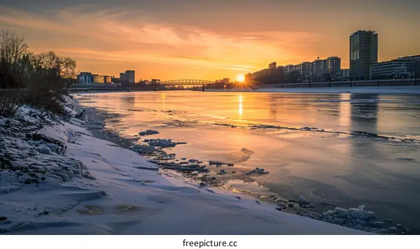 The sun sets over a frozen river in winter