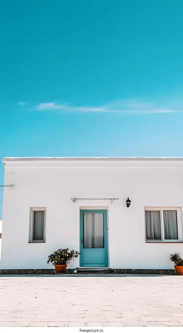White House with Blue Door and Patio Under Clear Blue Sky