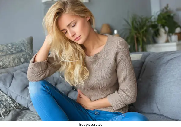 Woman Experiencing Abdominal Pain on Sofa