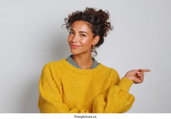 Young Woman in a Mustard Yellow Sweater Pointing