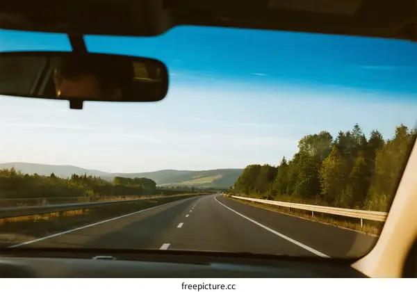 View from inside a car driving on a highway with clear sky