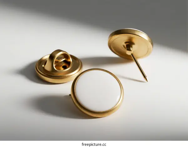 Elegant golden metal buttons with white circular faces on white background