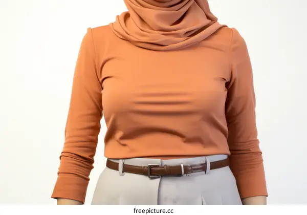 Middle Eastern woman wearing a brown turtleneck blouse and gray pants