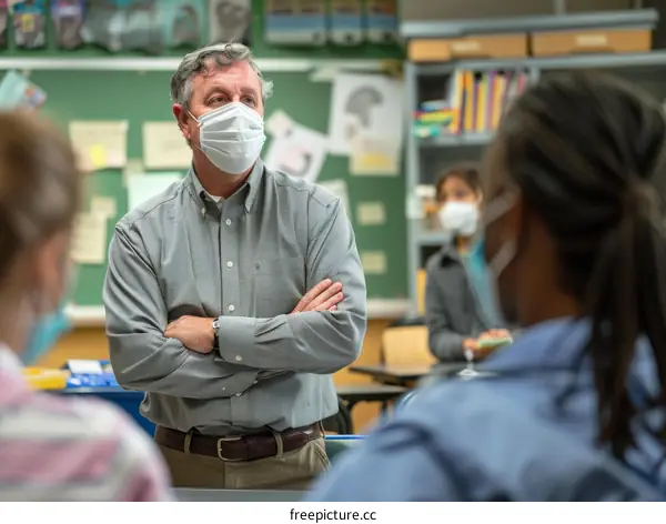 Teacher wearing a mask standing in a classroom with students