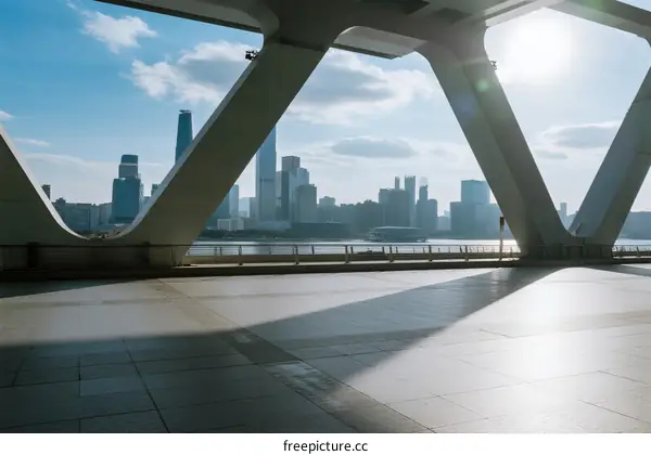 Modern cityscape viewed through structural framework under sunny sky