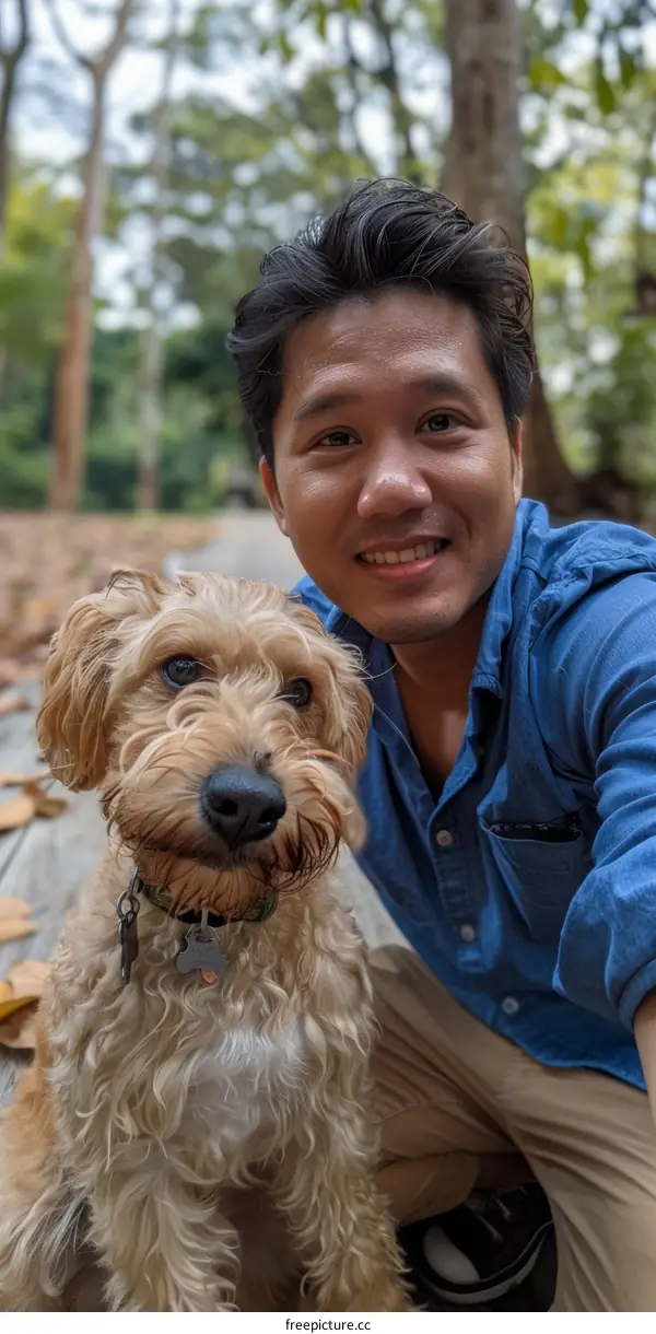A man and his dog are posing for a photo in a park