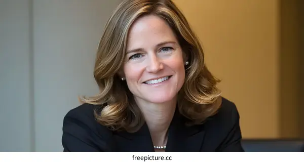 Portrait of a Smiling Woman with Blonde Hair in a Black Suit