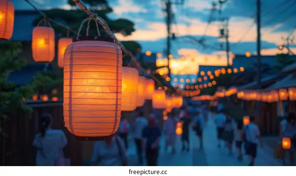 A lantern-lit street in Japan with people walking in the background