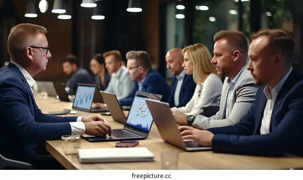 Group of diverse business professionals having a meeting and discussing financial data using laptop computers