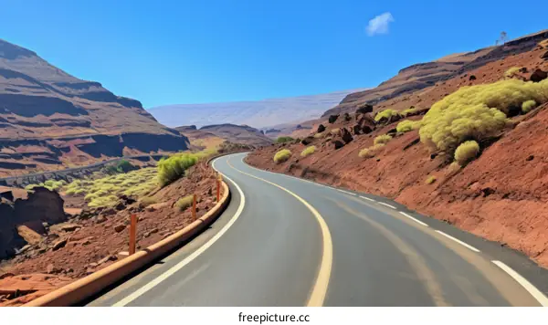 Road through a canyon with red rocks and green plants