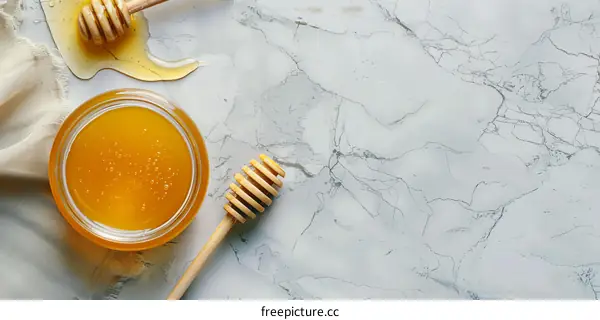 Honey Jar and Dipper on Marble Background