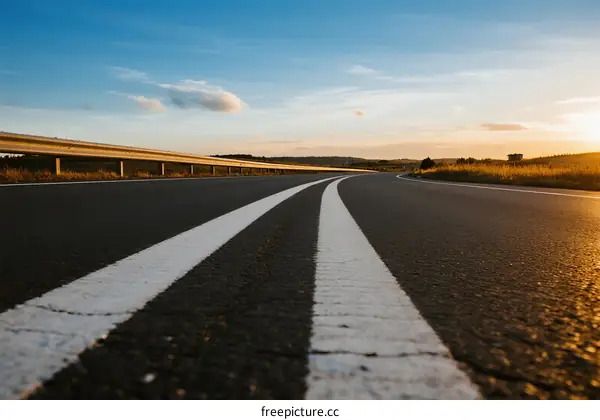 Sunset view of an empty highway with clear white lines