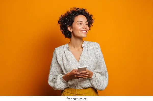 Smiling Woman with Curly Hair Holding Smartphone