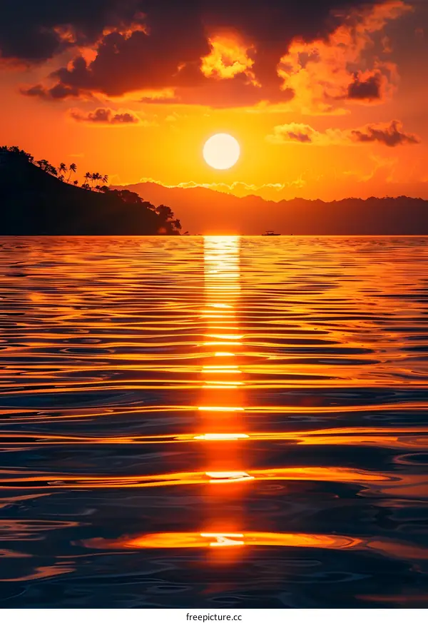 Sunset over calm sea with island silhouette