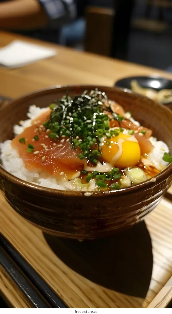 tuna sashimi rice bowl with egg yolk and scallions