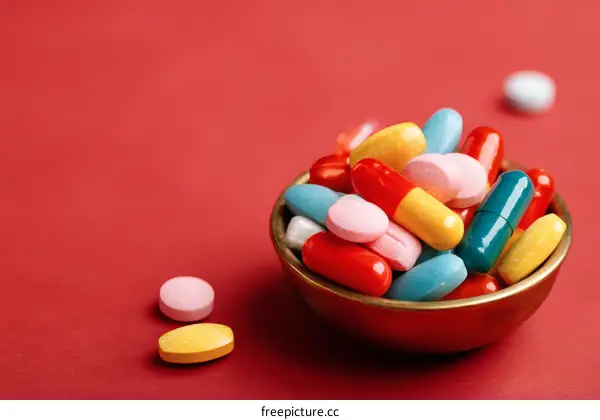 Colorful Pills in a Small Bowl on Red Background