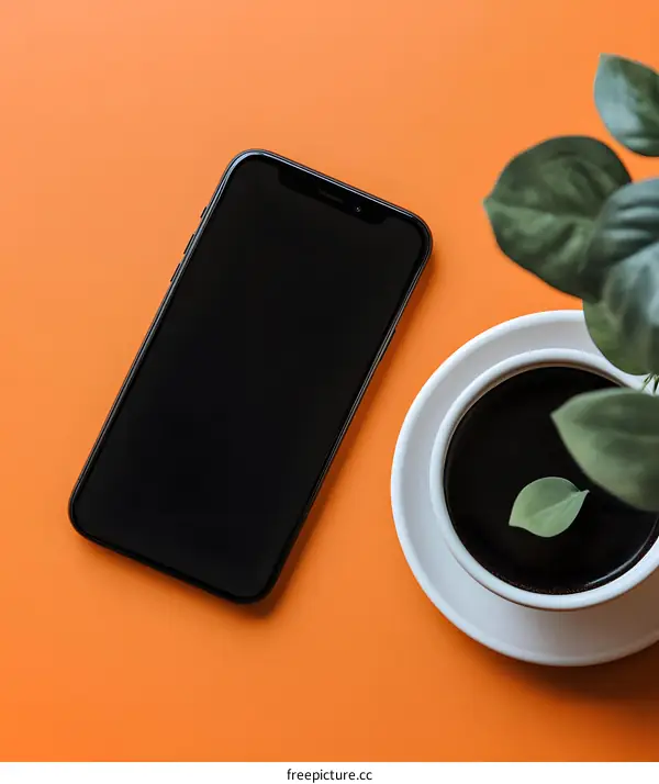 Black Phone with Coffee and Plant on Orange Background