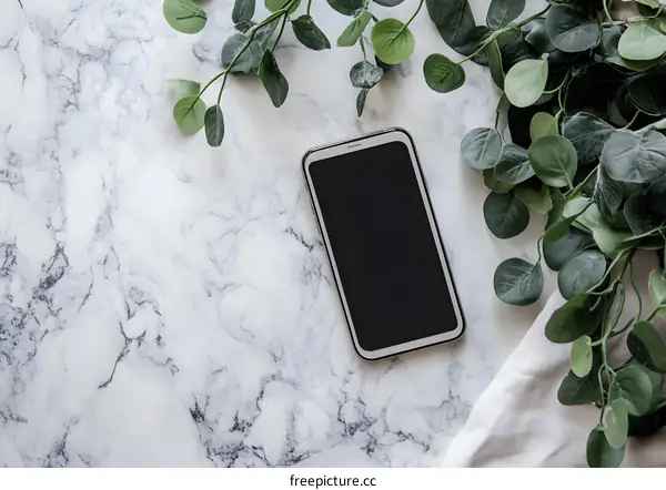 Modern Smartphone Mockup with Green Foliage on Marble Background
