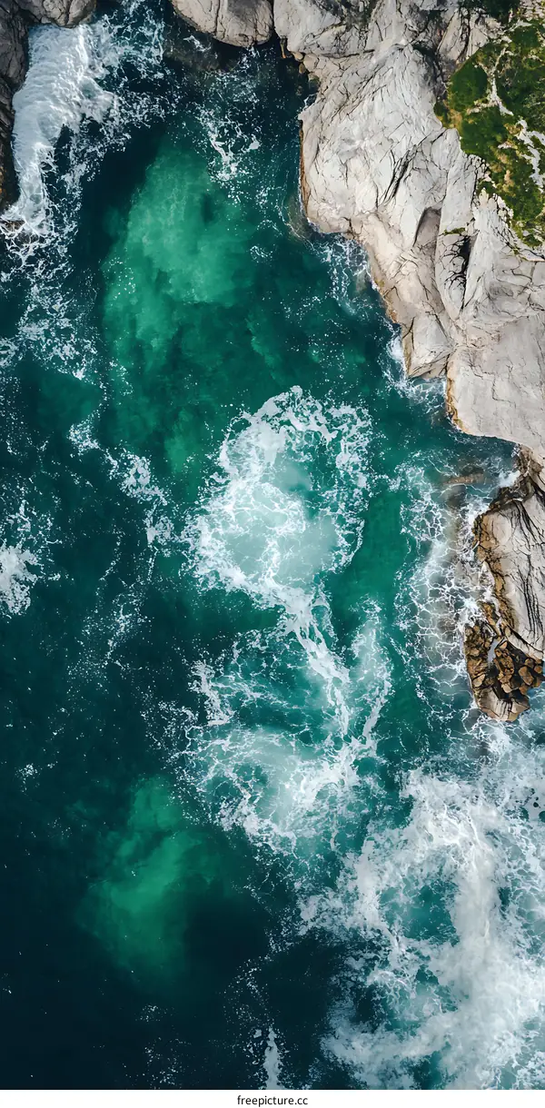 Aerial View of Ocean Waves Crashing Against Rocks