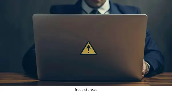 businessman working on laptop with exclamation mark