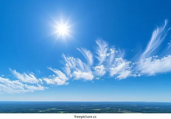 wispy white clouds float across a deep blue sky