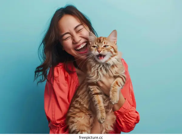 Laughing woman hugging a ginger cat
