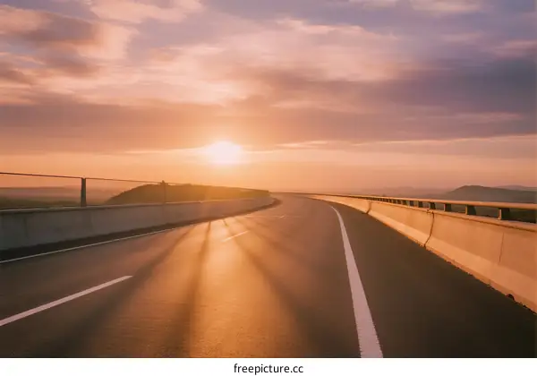 Sunset over a long and empty highway with warm light